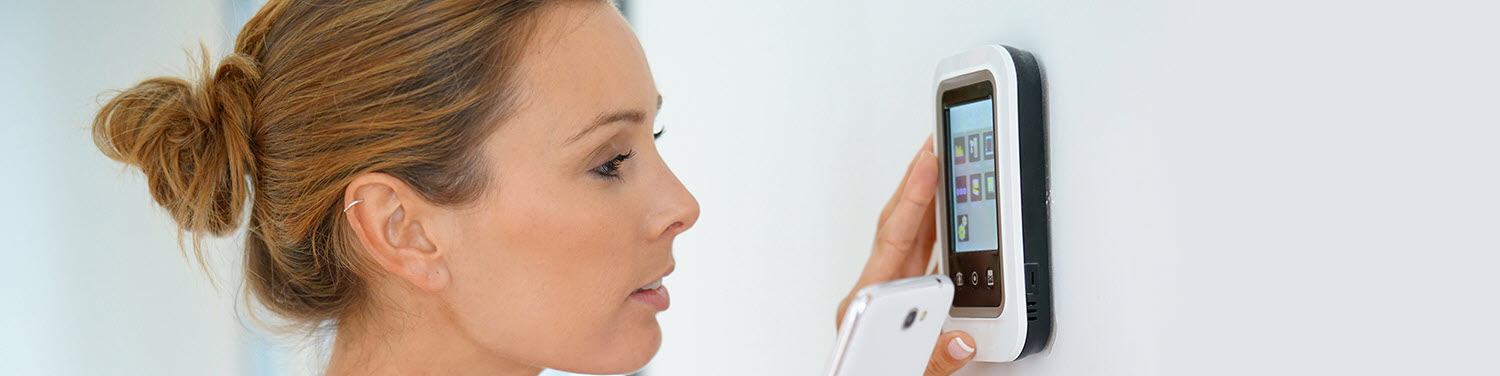 Woman programming a thermostat