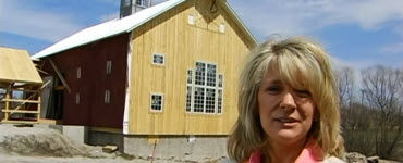 Megan standing in front of the barn home