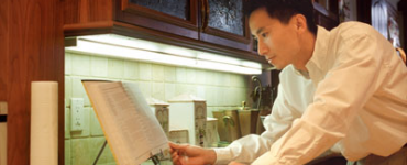 Man on computer near undercabinet light