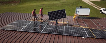 Workers installing solar panels on a roof