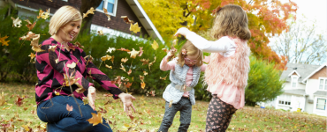 Mom and daughters playing in leaves