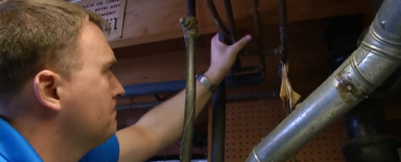 Man checking pipes in basement