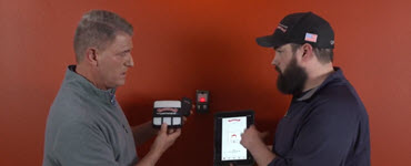 Pete and garage door specialist looking at garage door opener and phone app