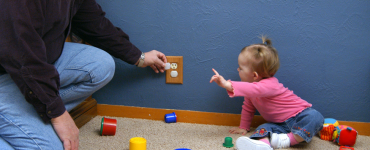 Man installing childproof outlet cap