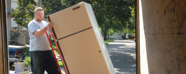 man hauling old refrigerator