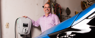 Man in garage with car and charger